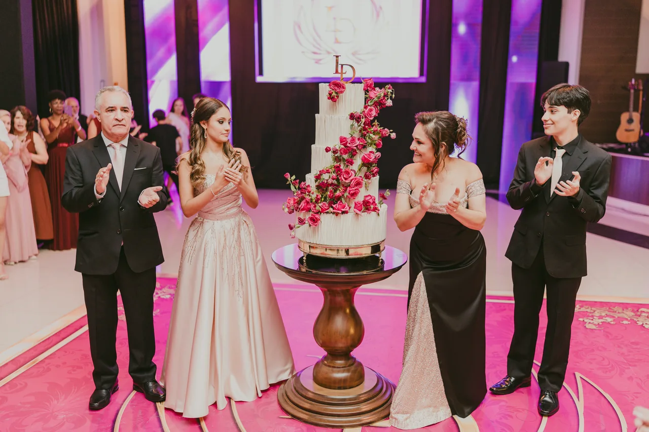 Debutante e família reunidos diante do bolo.