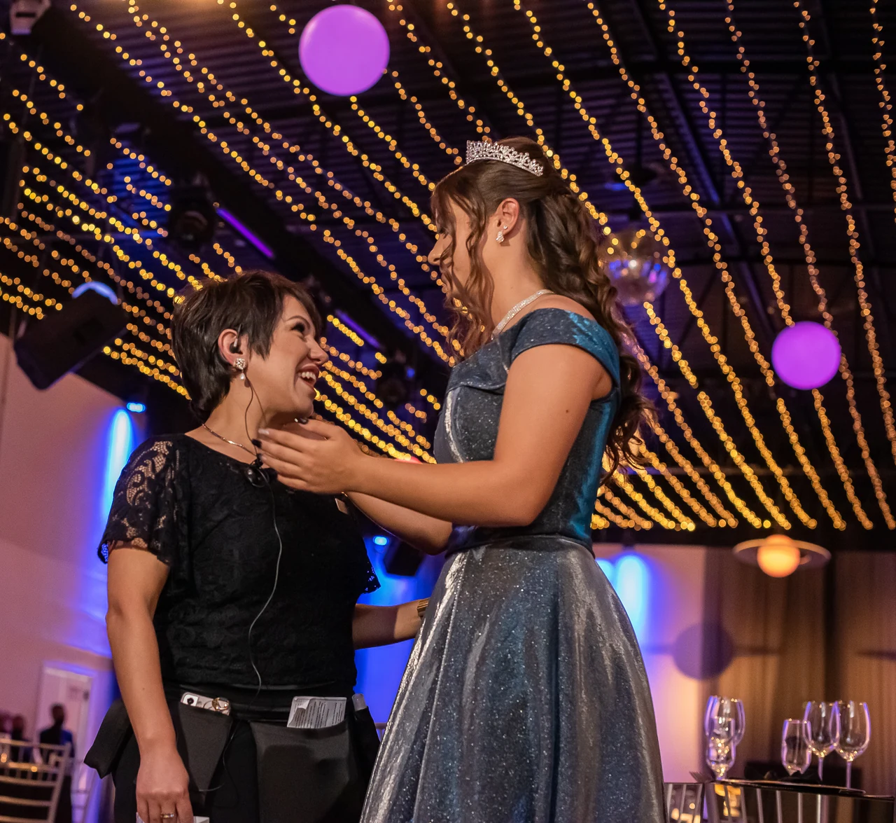 Juliana Porto acolhendo uma debutante durante sua festa de 15 anos.