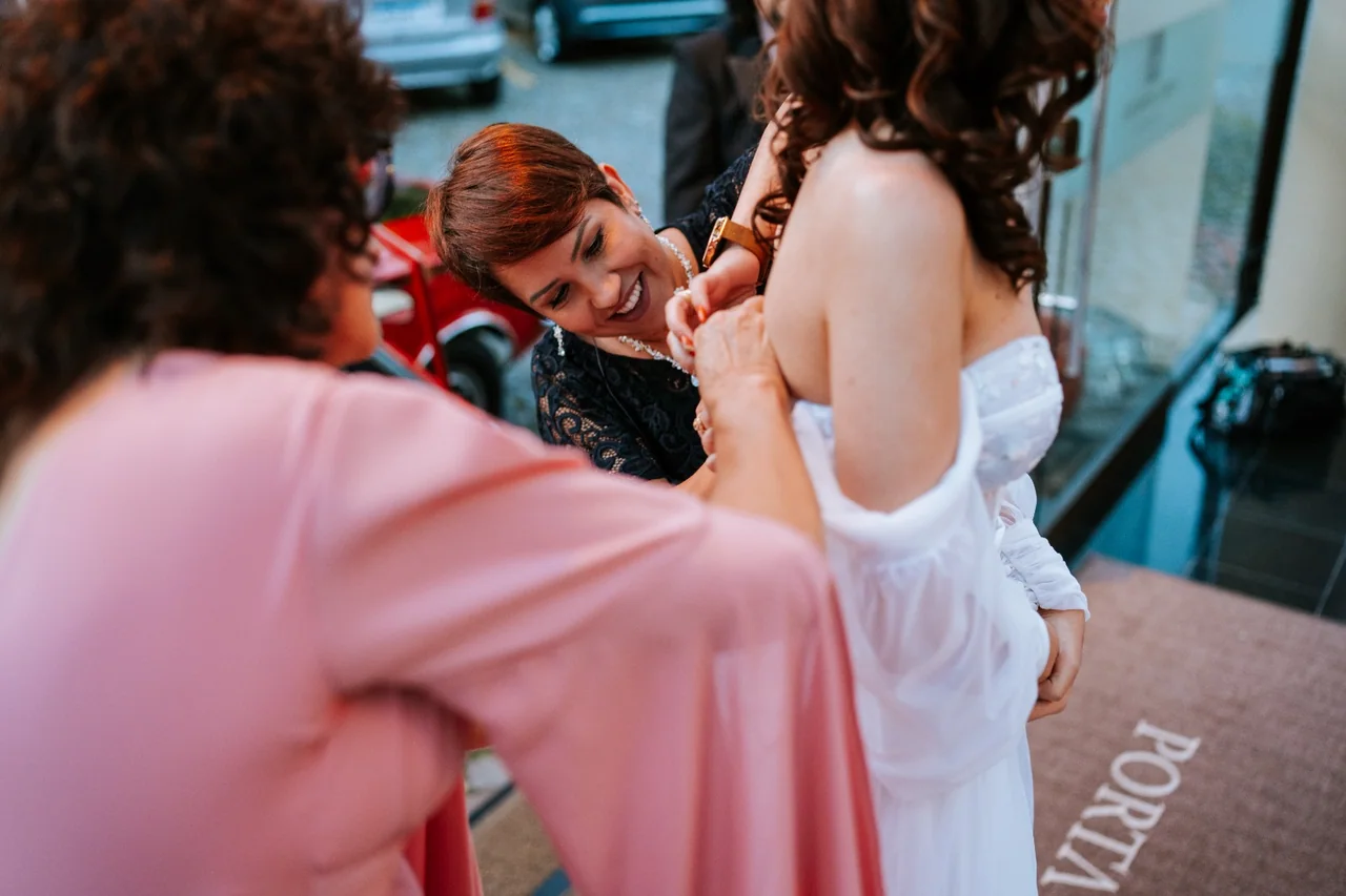 Juliana Porto ajudando a noiva antes da cerimônia.