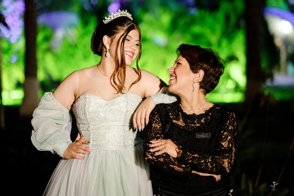 Juliana Porto e a debutante compartilhando um sorriso.