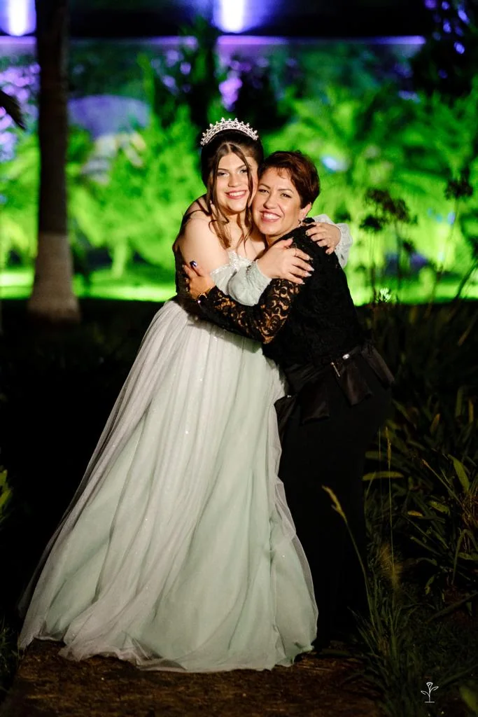 Juliana Porto abraçando a debutante na celebração.