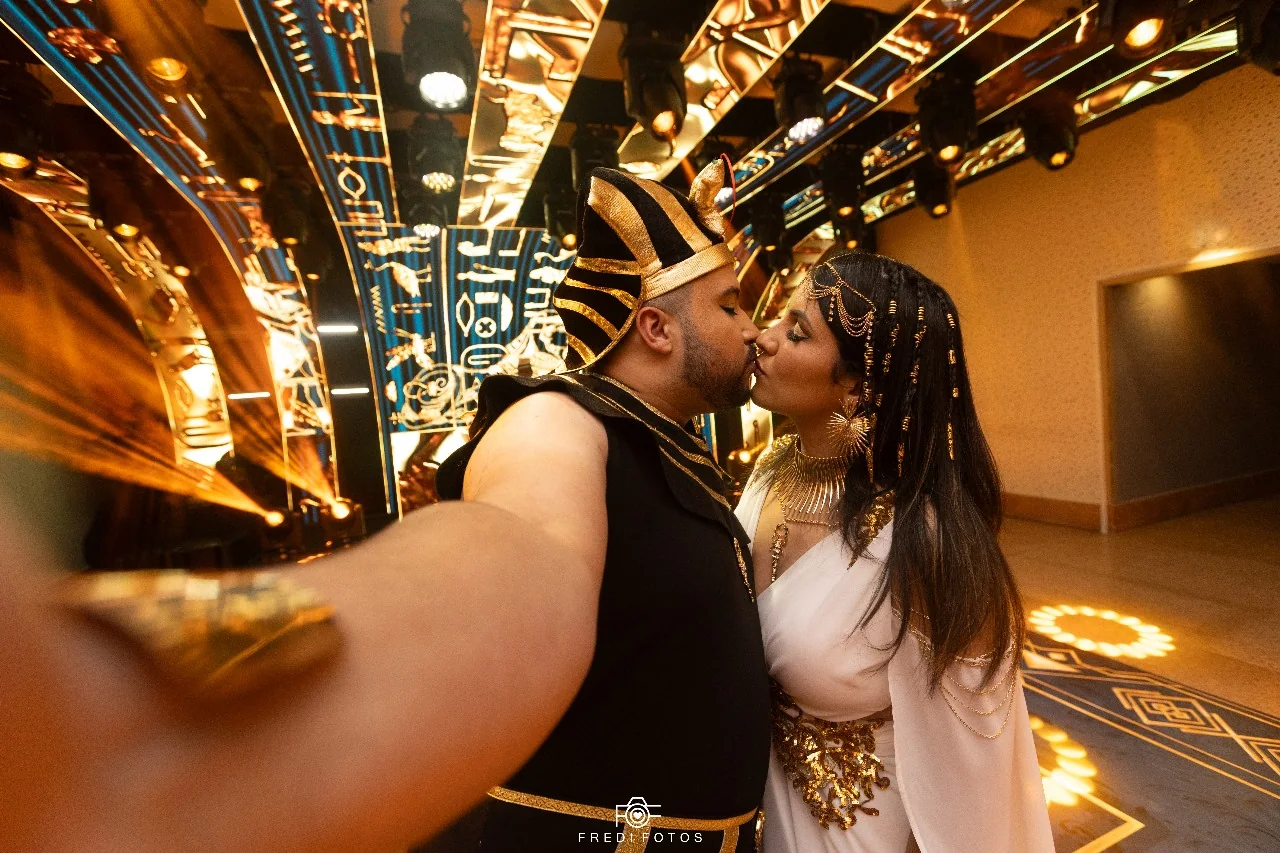 Casal compartilhando um beijo durante a festa temática.